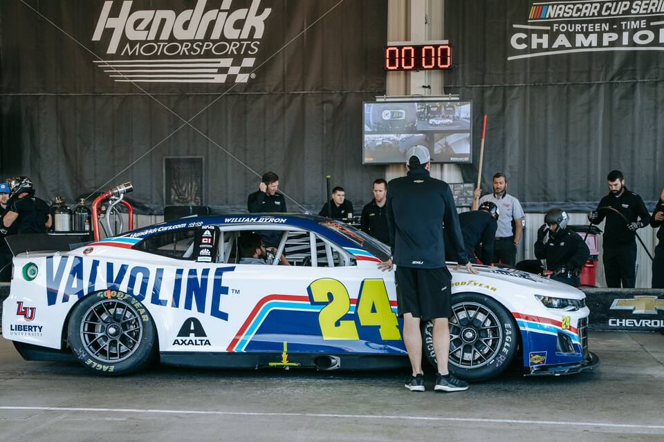 A race car with the number 24 parked at a pit stop.