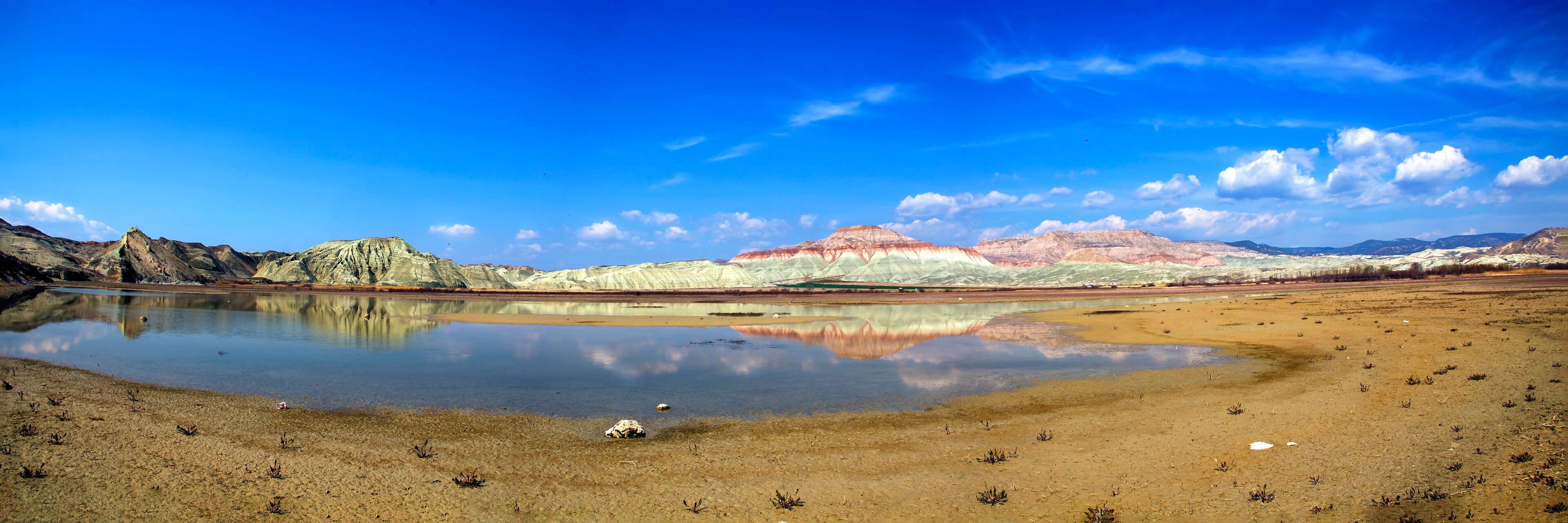 A lake reflecting mountains with a clear sky.