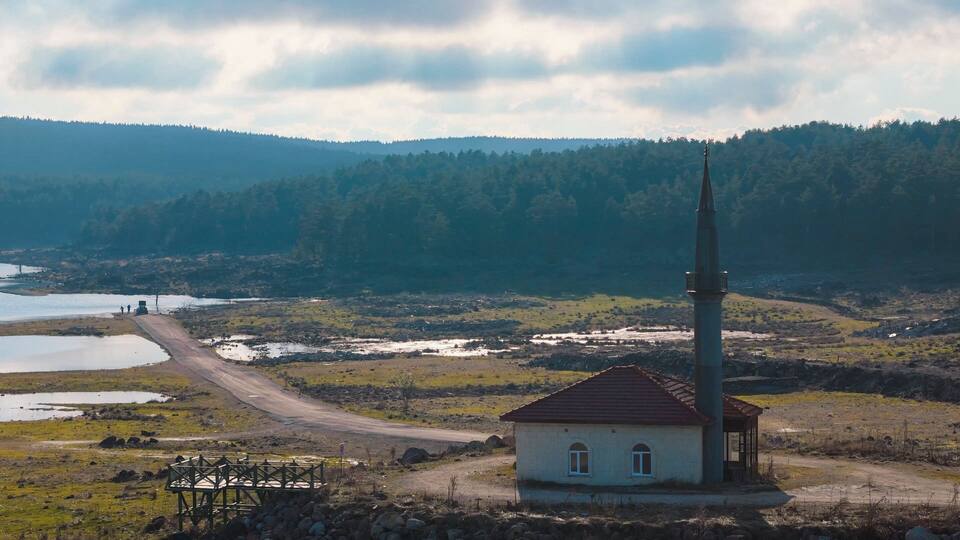 A rural landscape with a church, a watchtower, and a river.