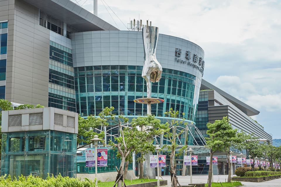 A modern building with large glass windows and a unique sculpture.