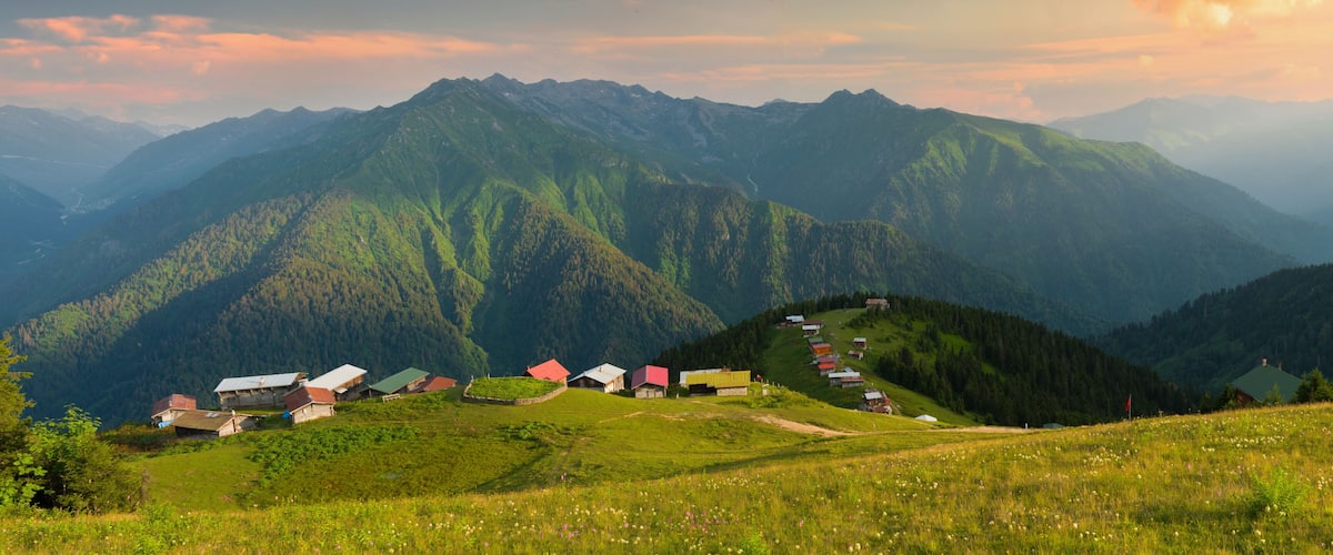 A mountainous landscape with a row of houses on a hillside.