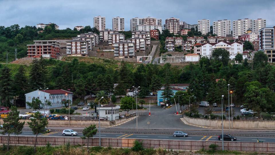 Un paysage urbain comprenant des immeubles d’habitation, une autoroute et le centre d’une petite ville.