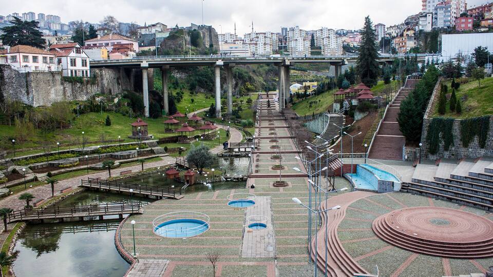 Un parc doté d’une grande piste circulaire, d’un petit étang et d’un pont enjambant une rivière.