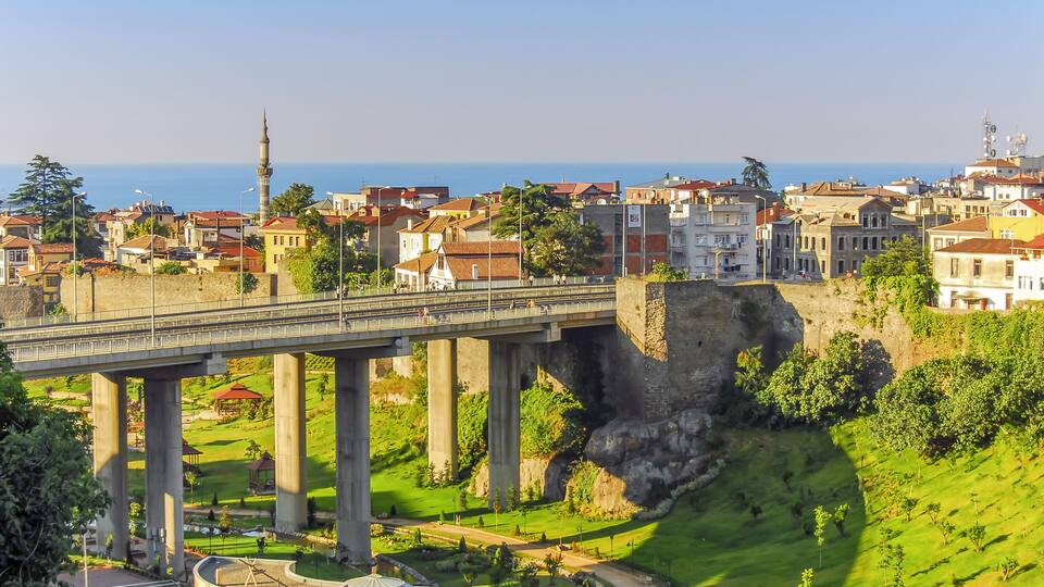 Un pont enjambant une vallée, avec une mosquée et un château en arrière-plan.