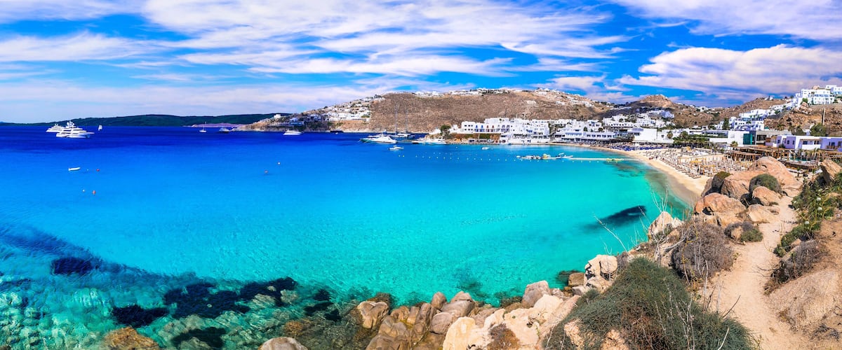 A coastal town with clear blue waters, boats, and white buildings.