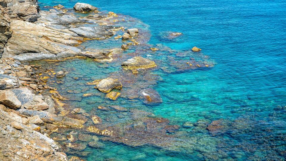 A rocky shoreline with clear blue water.