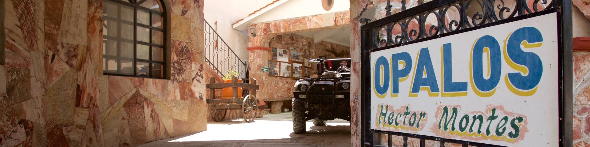 A rustic building with a sign reading "OPALOS Hector Montes" and a yellow sign indicating "LAS MINAS OPALOS MONTES".