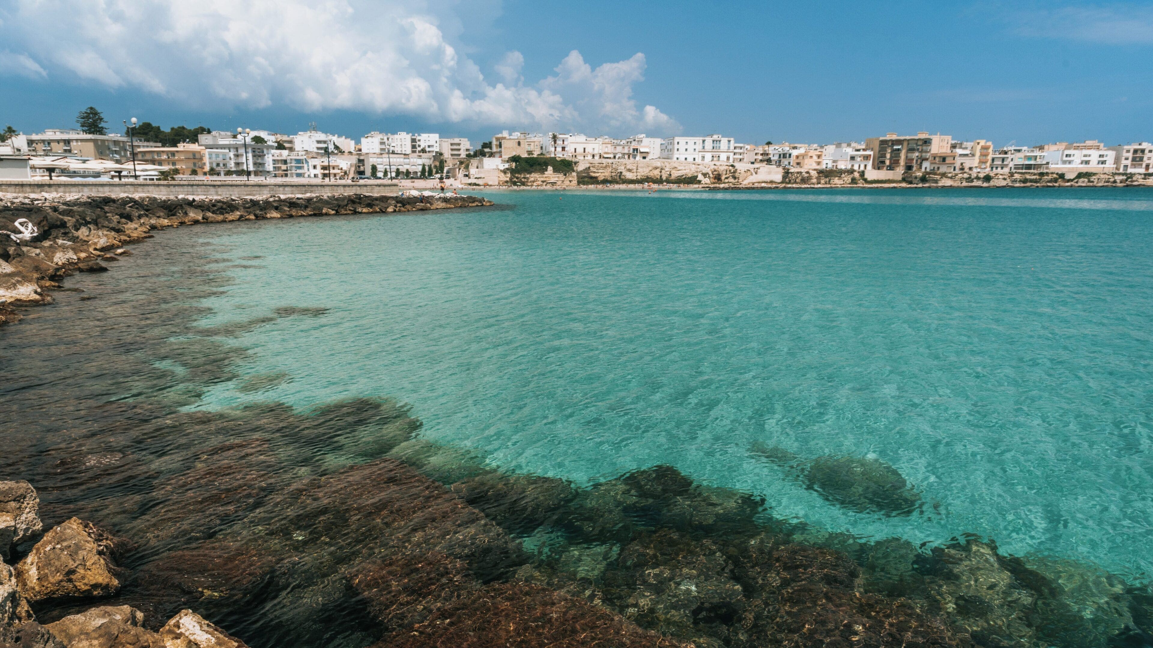 Exploring the crystal-clear waters and historic charm of Otranto Waterfront in Puglia, Italy, under a bright blue sky