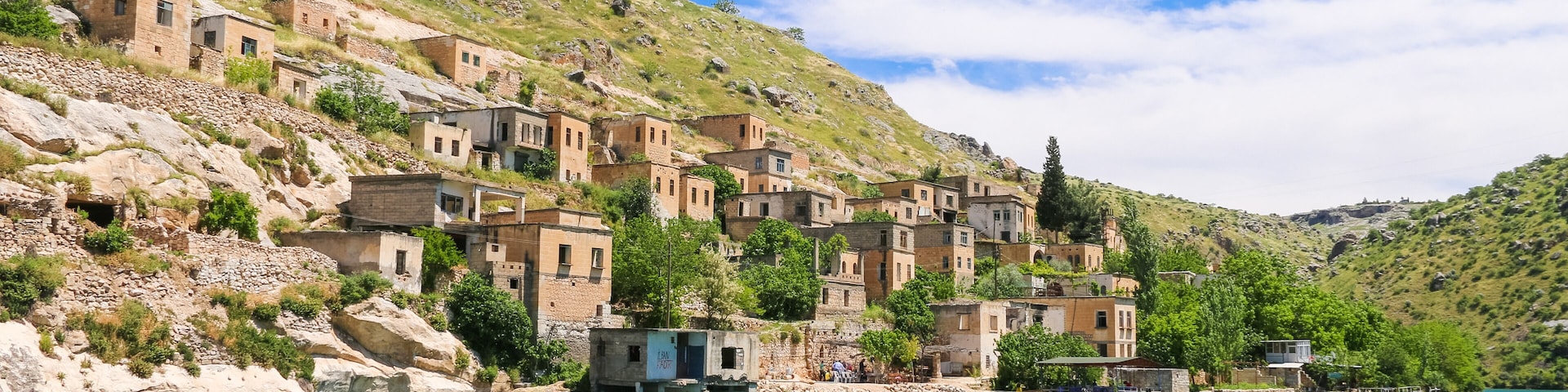 Un pueblo costero con casas escalonadas en una colina, con vistas al mar turquesa.