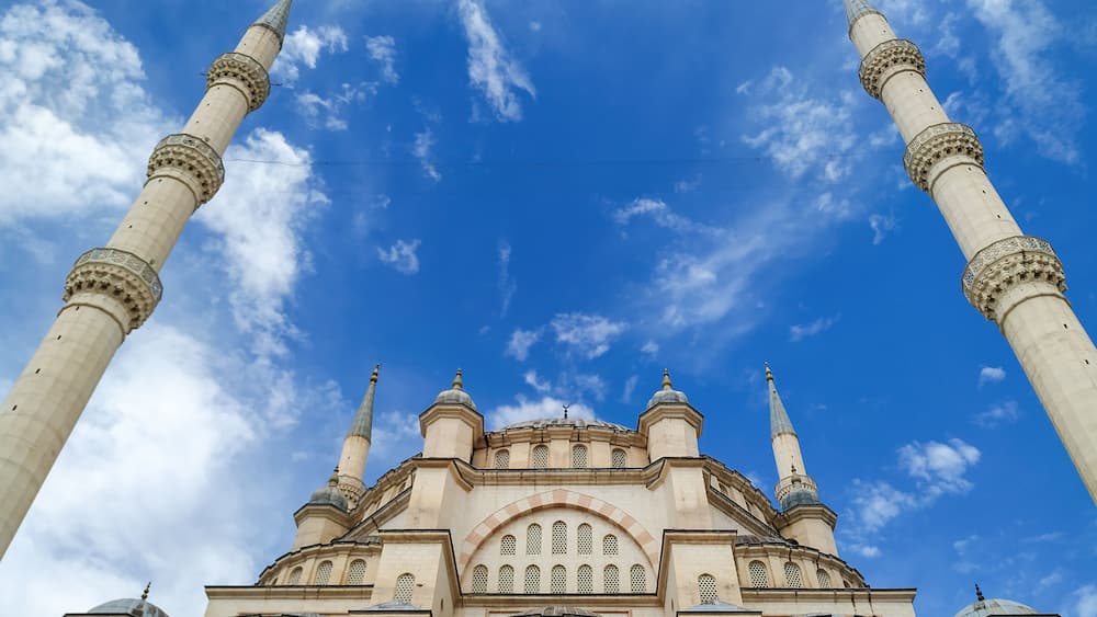 A mosque with four minarets and a large central dome.