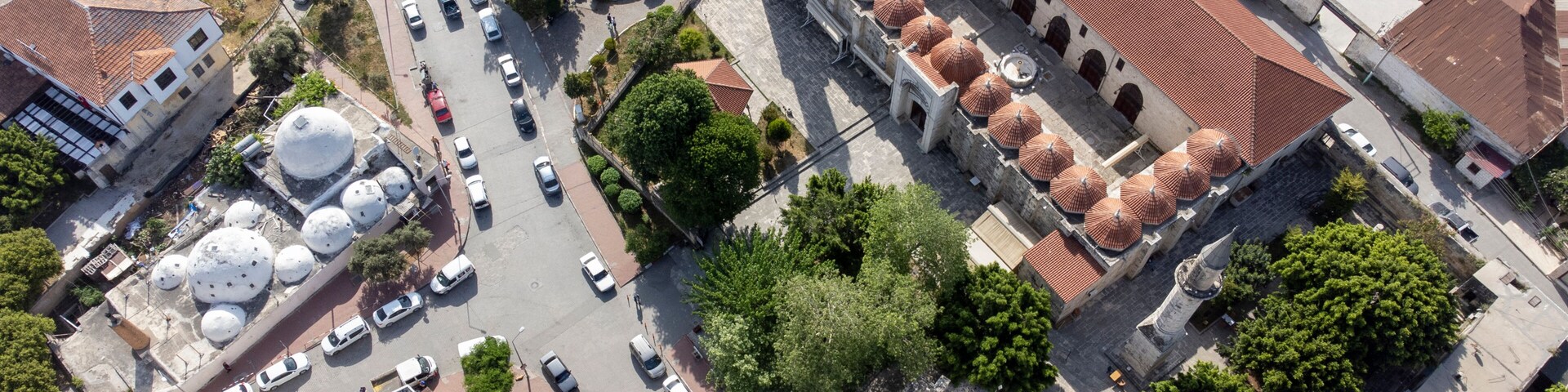 Vista aérea de una ciudad con una mezquita destacada que presenta múltiples cúpulas y un minarete.