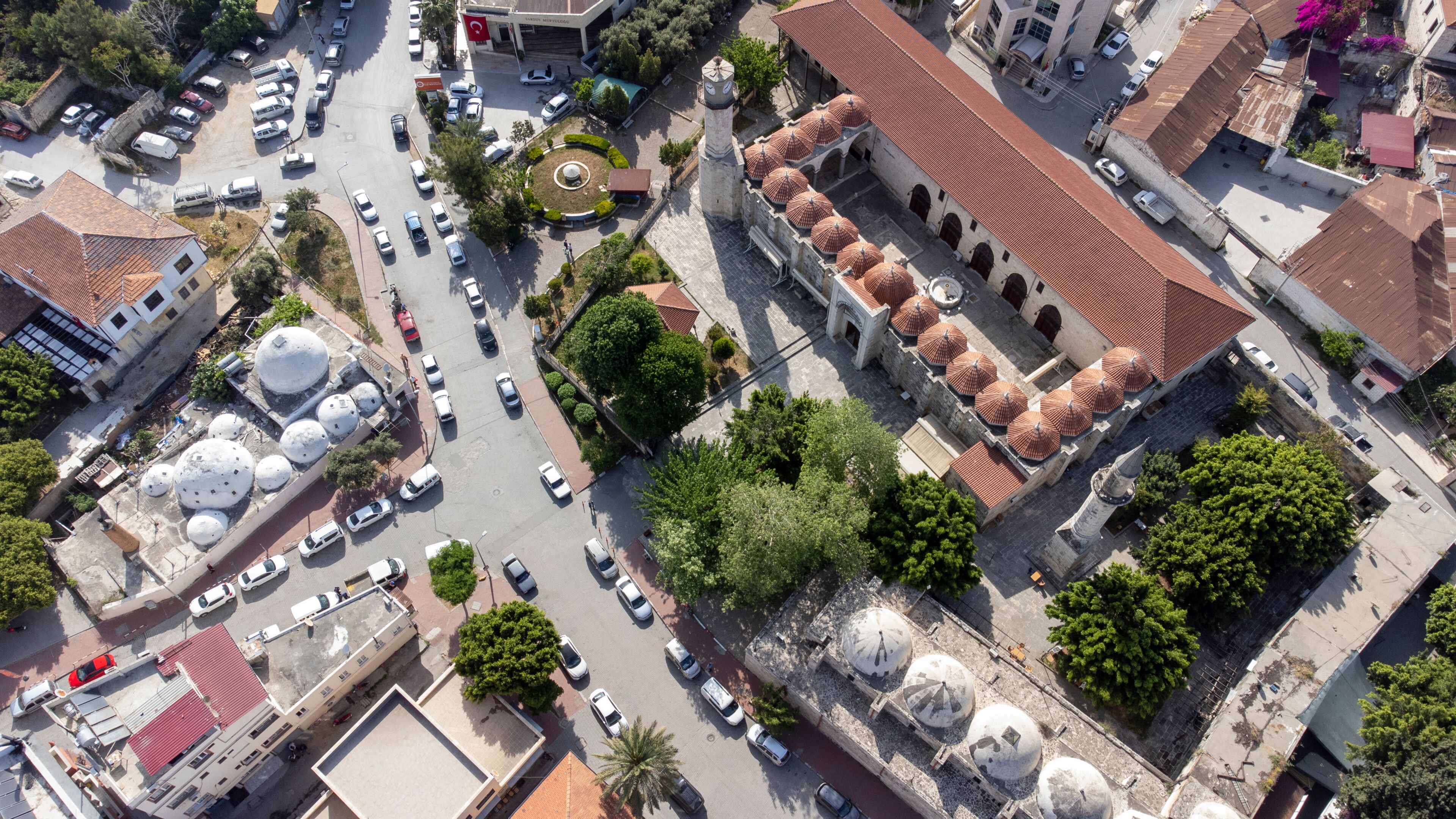 An aerial view of a city with a prominent mosque featuring multiple domes and a minaret.