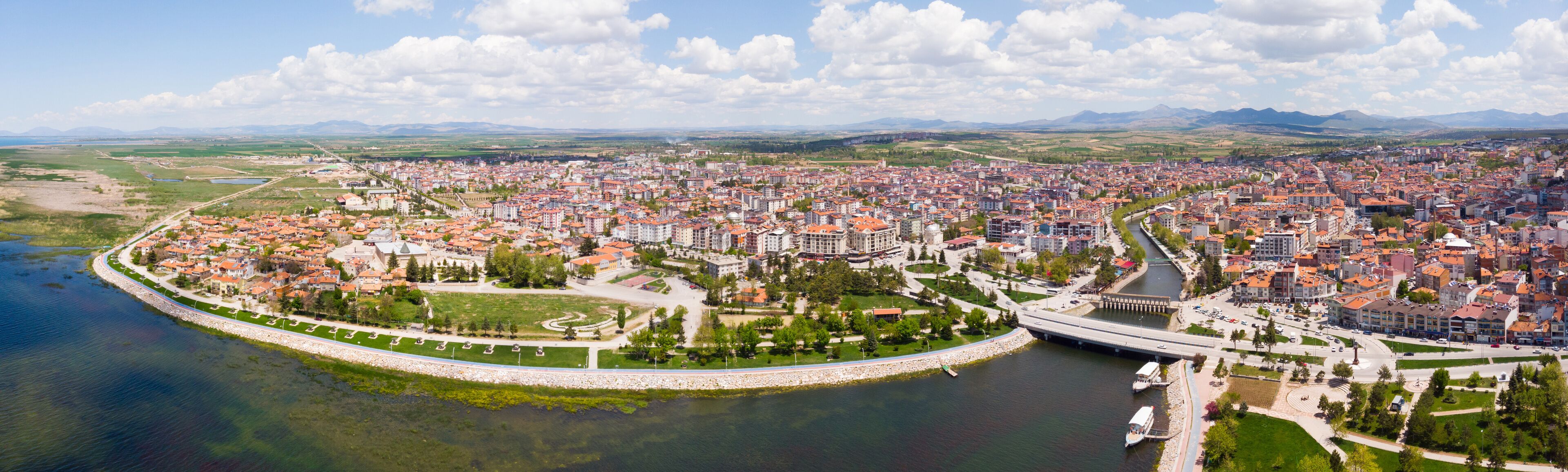 A coastal city with a river, a bridge, and surrounding mountains.