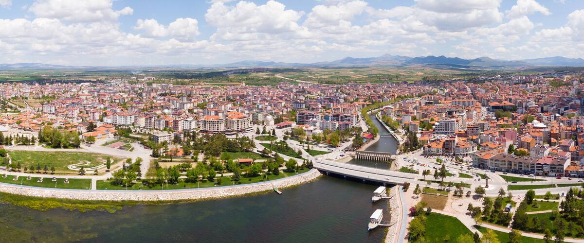 A coastal city with a river, a bridge, and surrounding mountains.