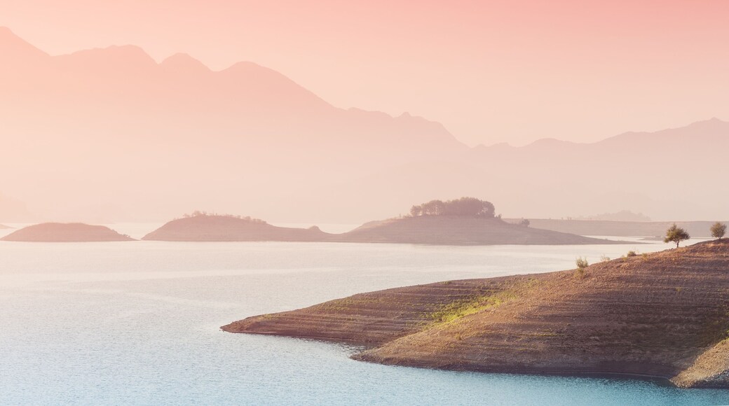 Panoramic inspirational and tranquil landscape in the rays of the sun in the morning. Idyllic nature with silhouettes of the Taurus mountains. Karacaoren lake in the Isparta region of Turkey.