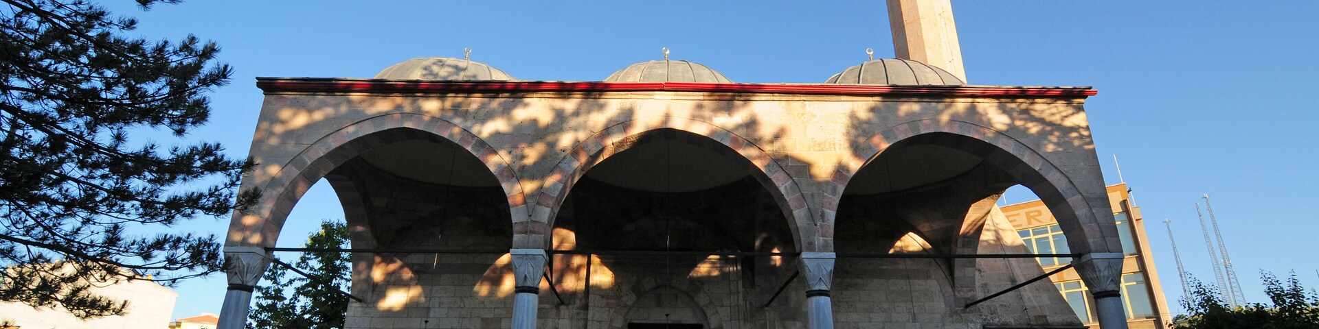 Una mezquita con tres arcos y un minarete.