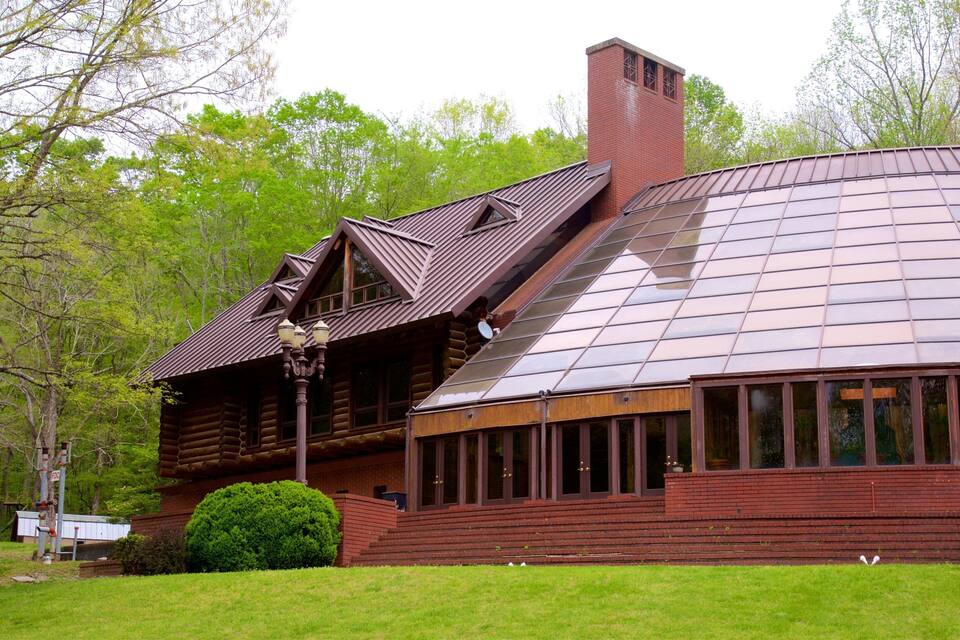 A wooden log cabin with a large glass conservatory.