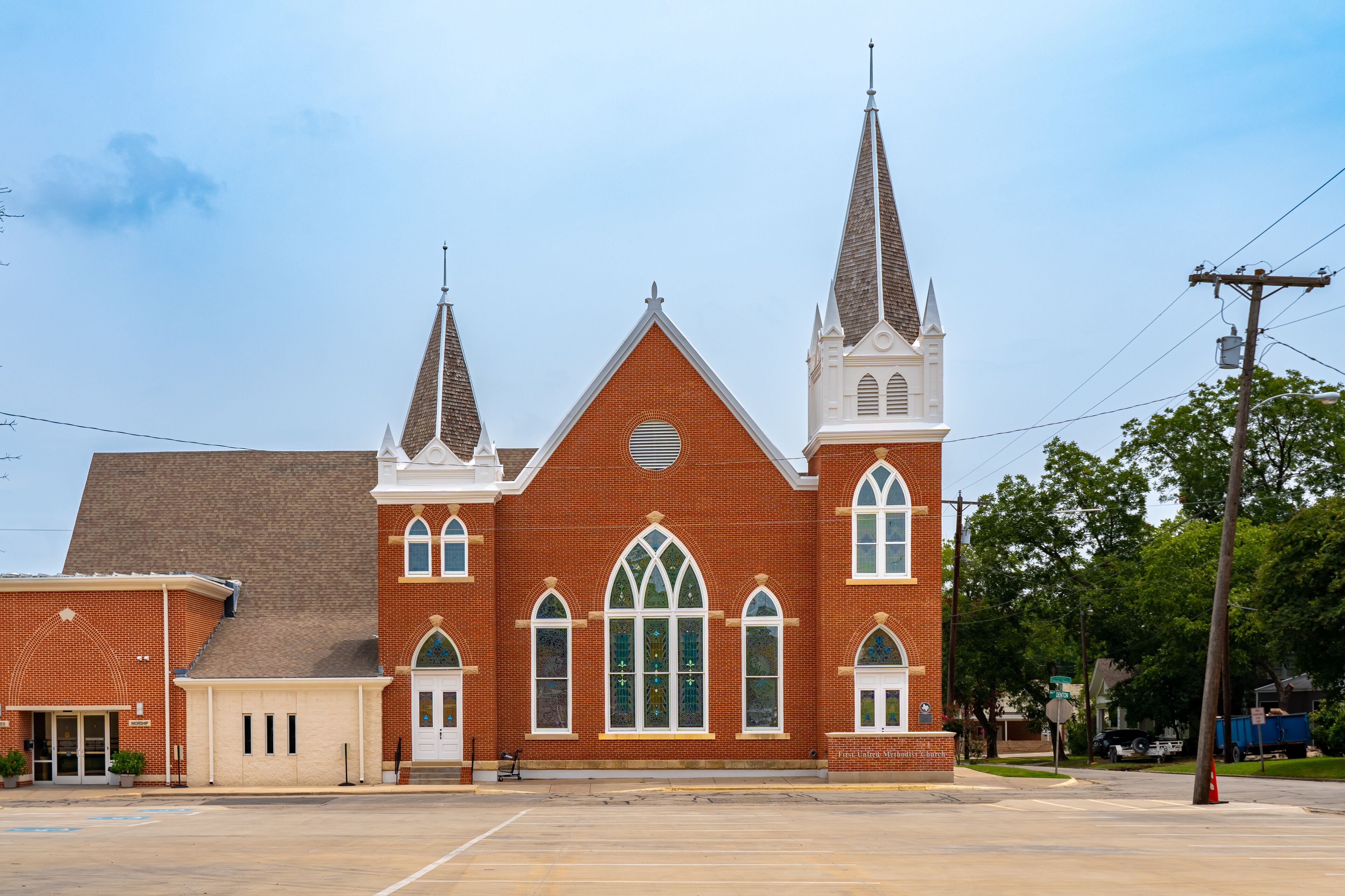 A large brick church with two steeples and arched windows.