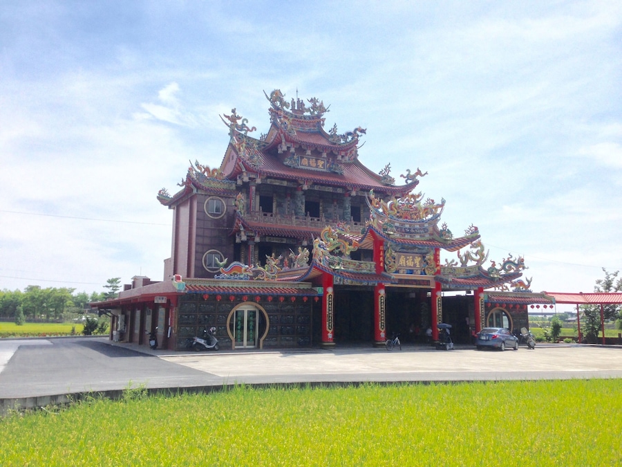 Un templo tradicional de varios niveles con decoraciones elaboradas y un tejado rojo.