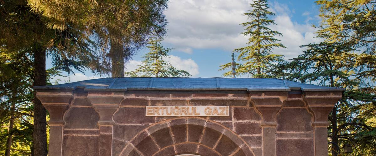 A stone archway with the inscription "ERTUGRUL GAZI" and a door beneath it.