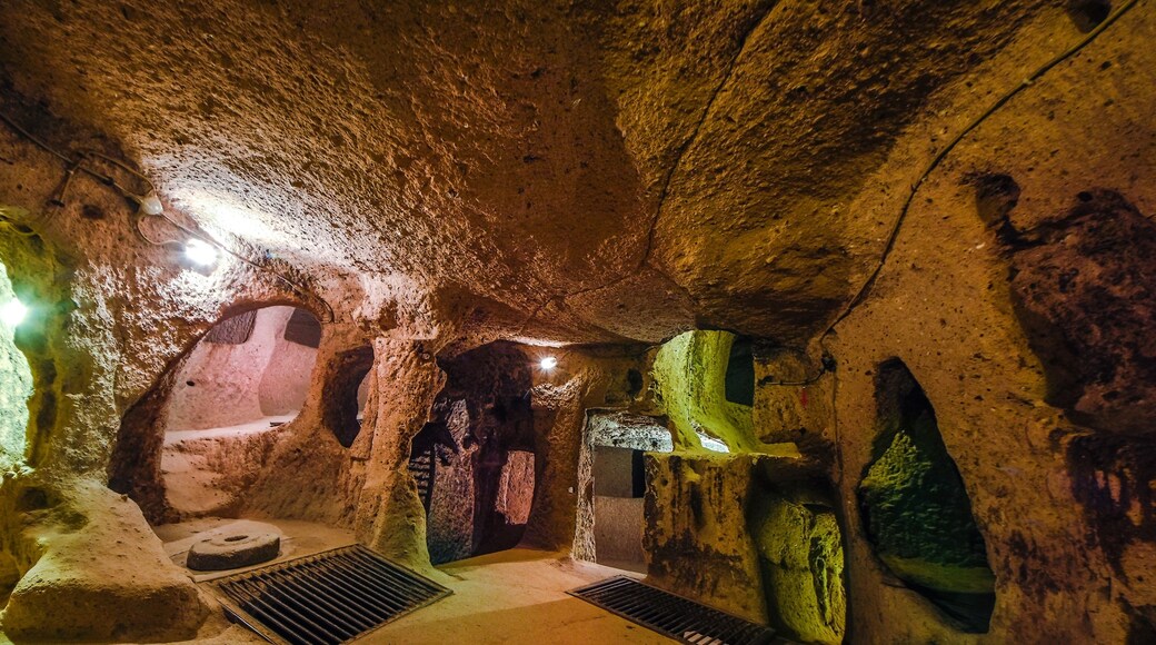 A cave interior with stalactites, a water drainage system, and a natural archway.