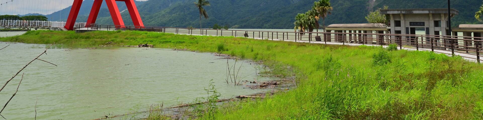 Taiwan - Aug 11, 2025: Dapu Lakeside Park connected to Lovers Park via Tongxin Suspension Bridge at Tsengwen Reservoir, featuring green lawns and scenic lake views.