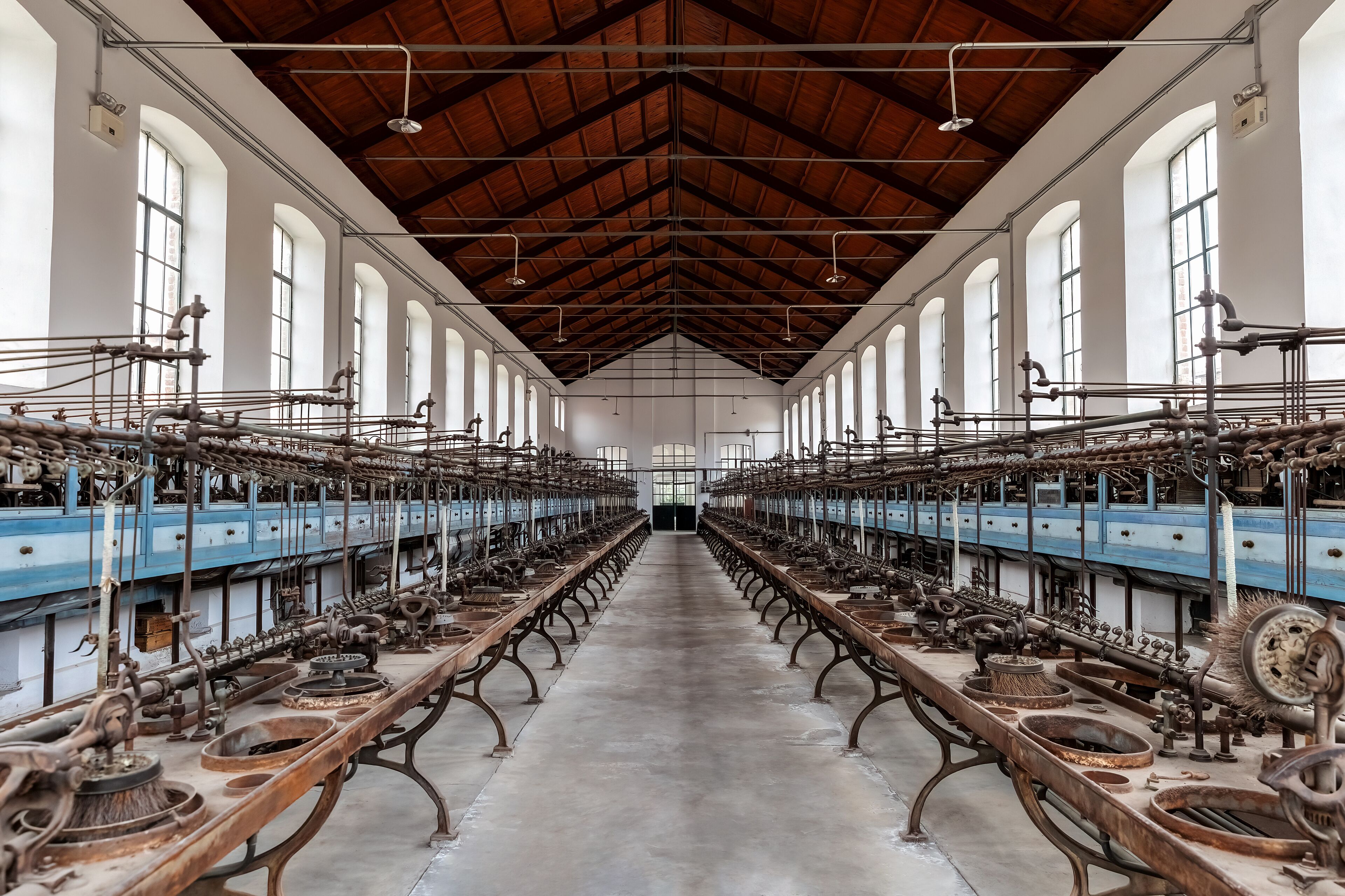 A large industrial building with rows of machinery and large windows.