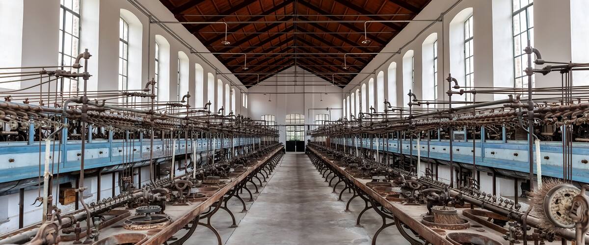 A large industrial building with rows of machinery and large windows.