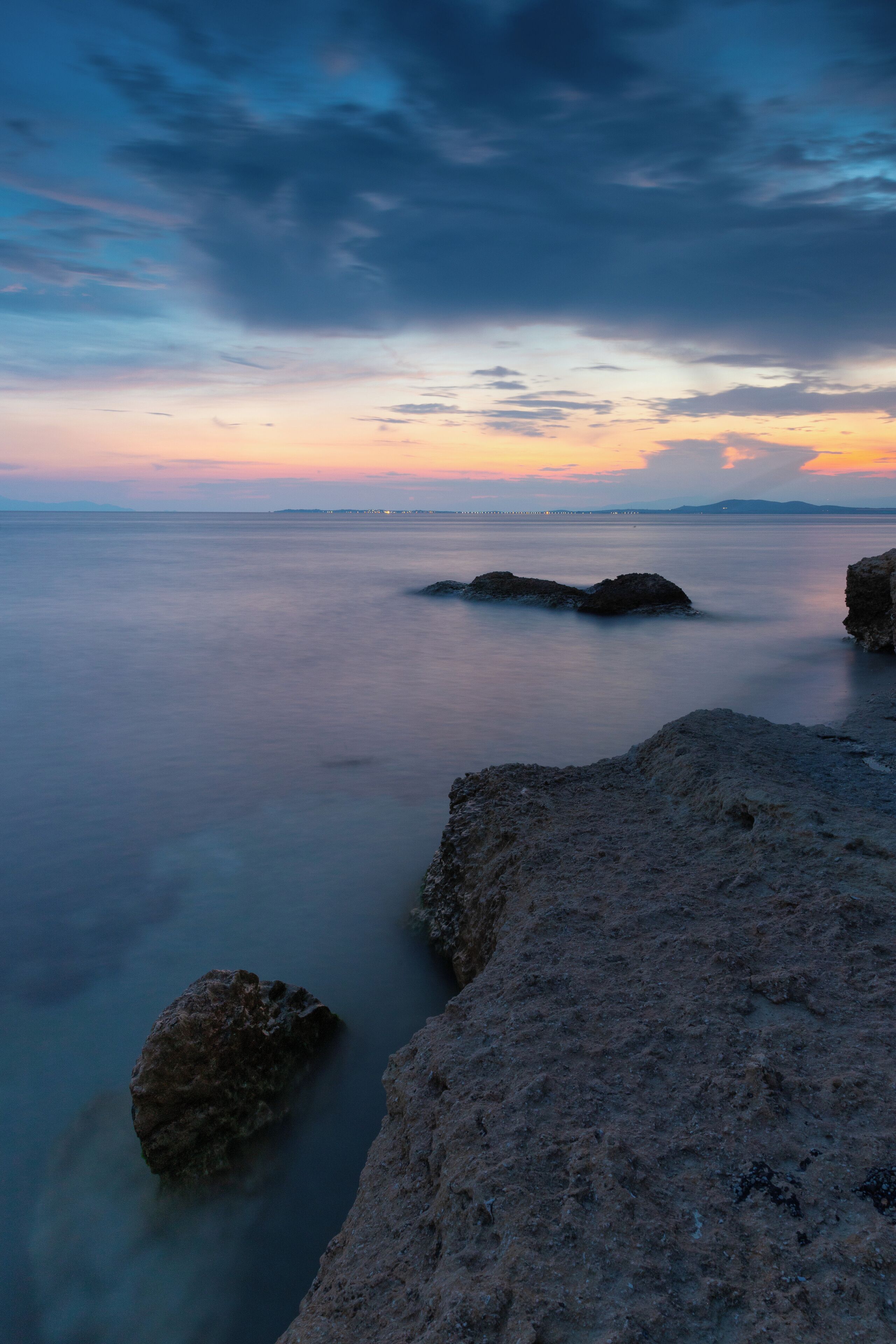 A coastal landscape with rocky formations and calm waters.
