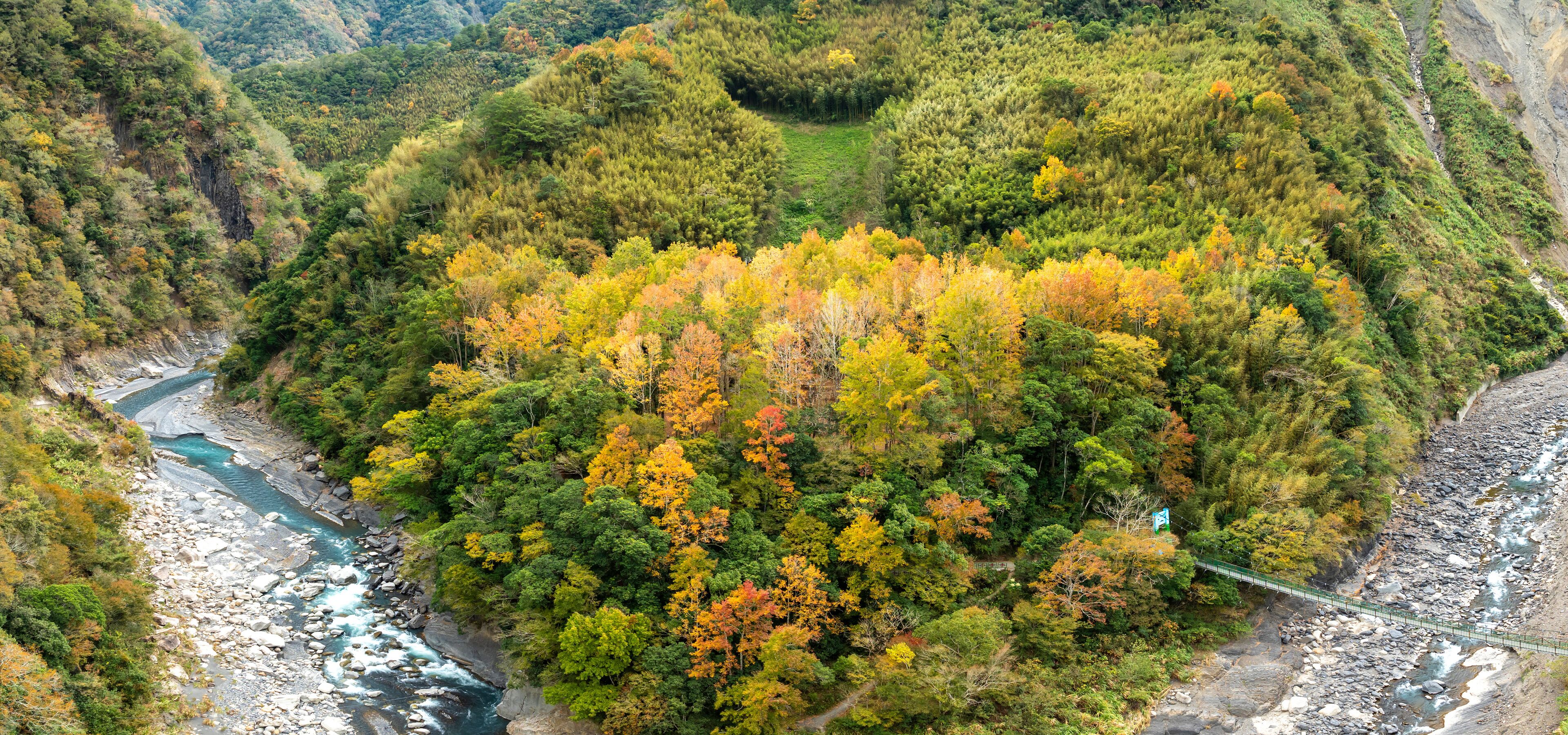 A river winding through a forested valley with autumn foliage.