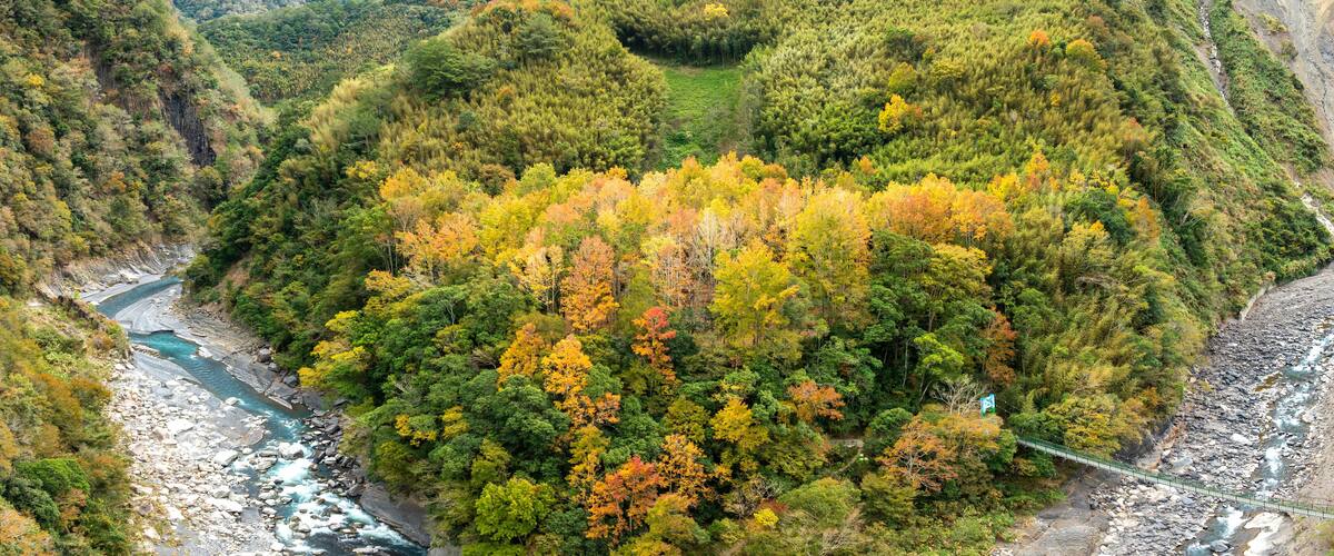 A river winding through a forested valley with autumn foliage.