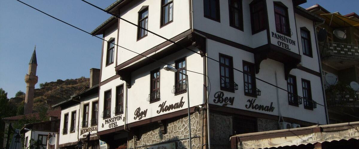 Un edificio de dos pisos con el letrero "Bay Konak Restaurant" en la planta baja.