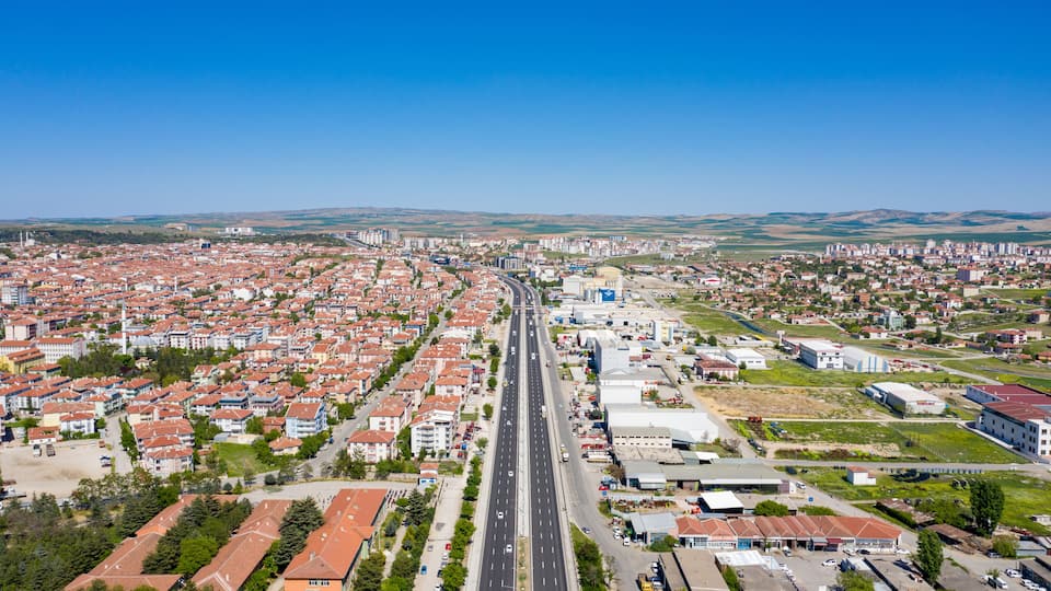 A cityscape with a central road, residential areas, and industrial buildings.