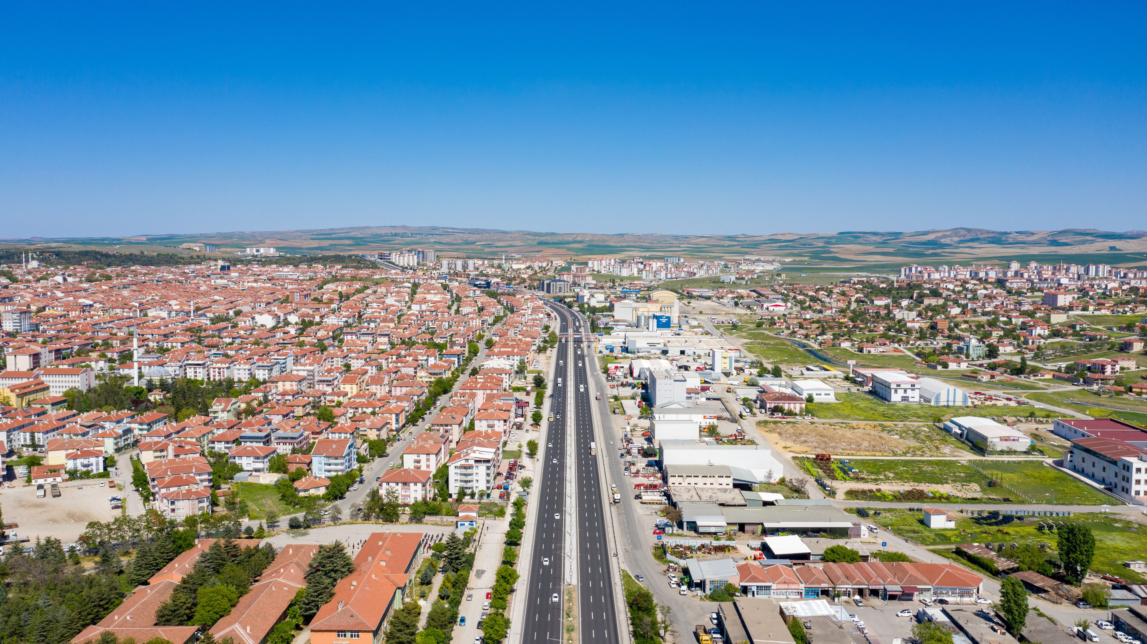 A cityscape with a central road, residential areas, and industrial buildings.