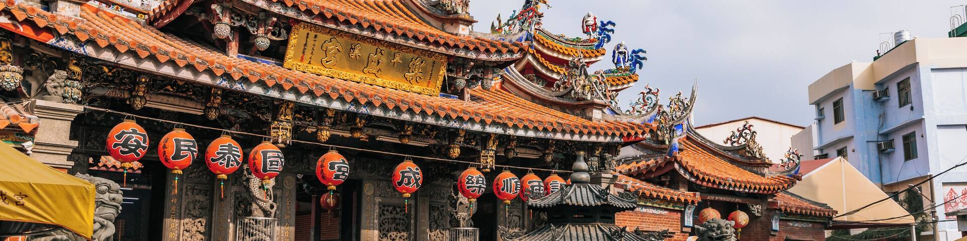 A traditional Chinese temple with ornate architecture, red lanterns, and statues.