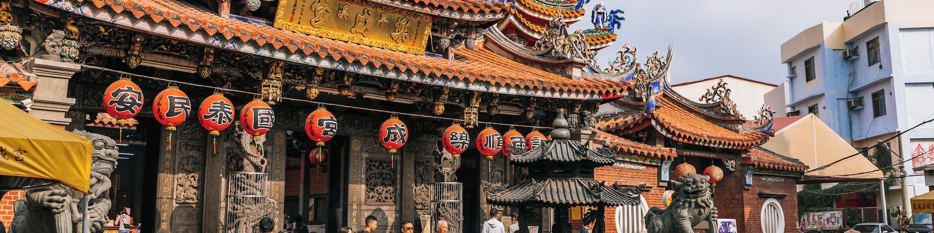Un temple chinois traditionnel, caractérisé par son architecture richement décorée, ses lanternes rouges et ses statues.