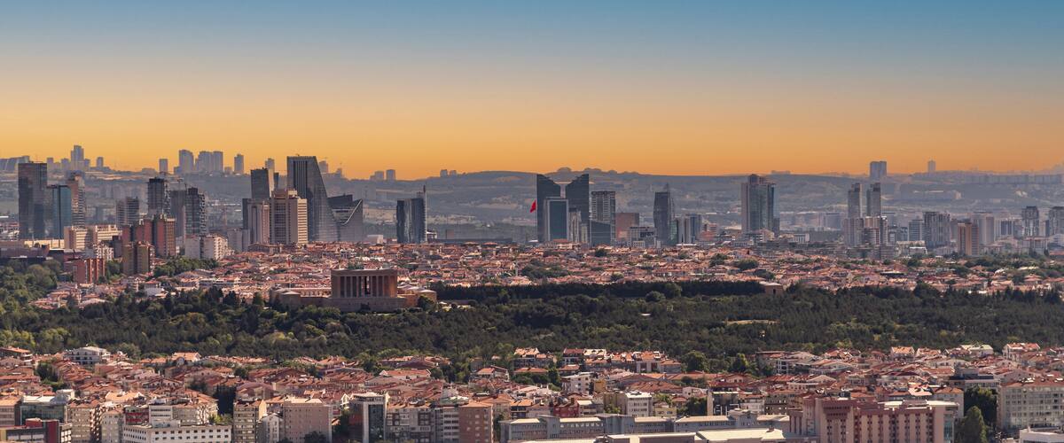 A cityscape with a mix of modern skyscrapers and historical architecture, including a prominent ancient temple.