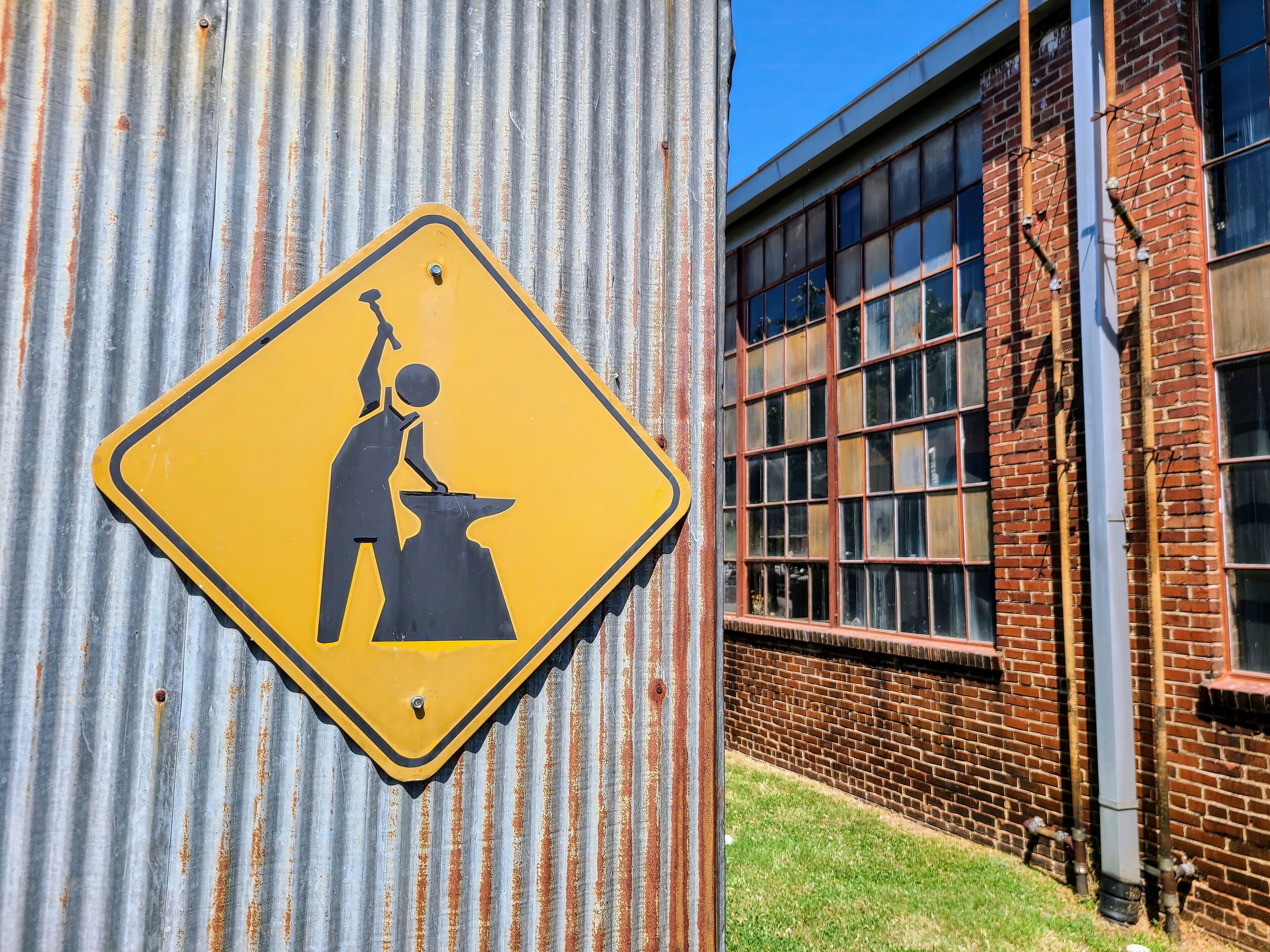 Industrial Caution Sign on Corrugated Metal Eye-Level Perspective