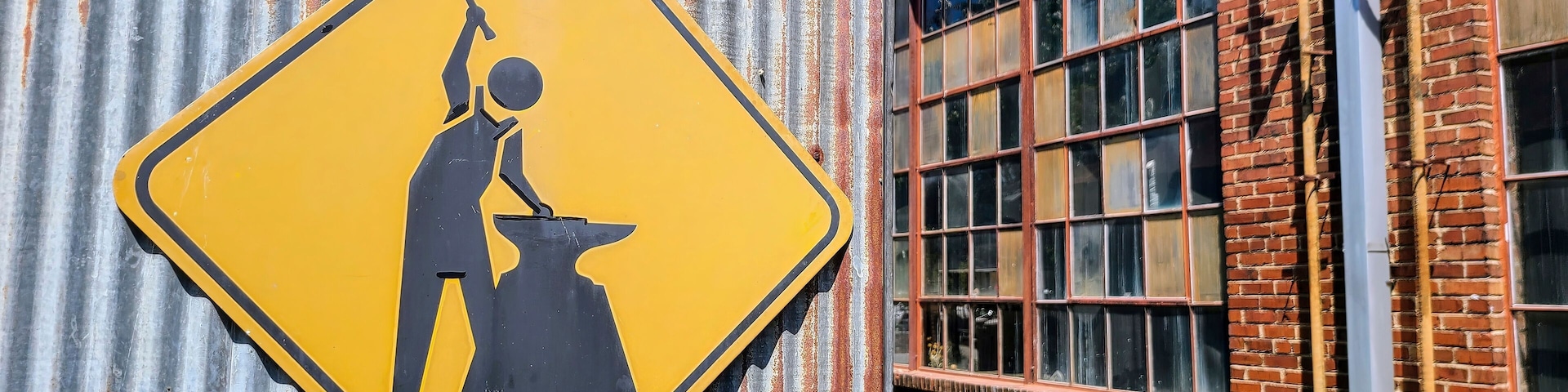 Industrial Caution Sign on Corrugated Metal Eye-Level Perspective