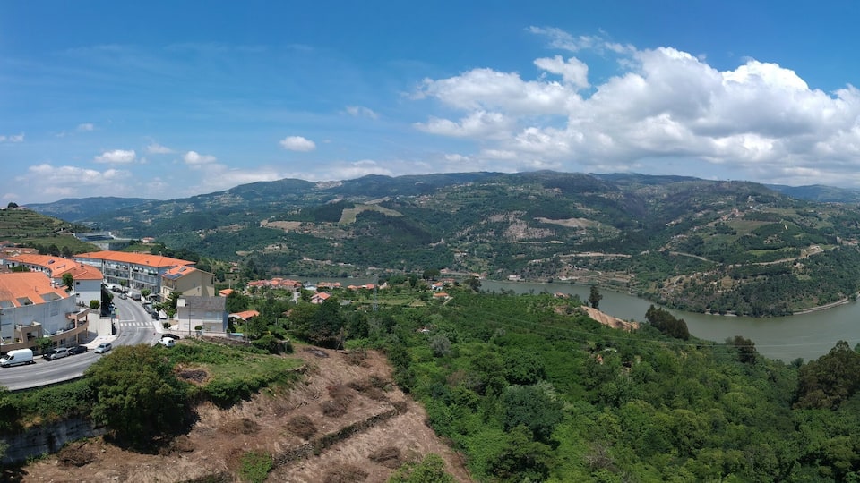 A river valley with a town on the left and a hill on the right.