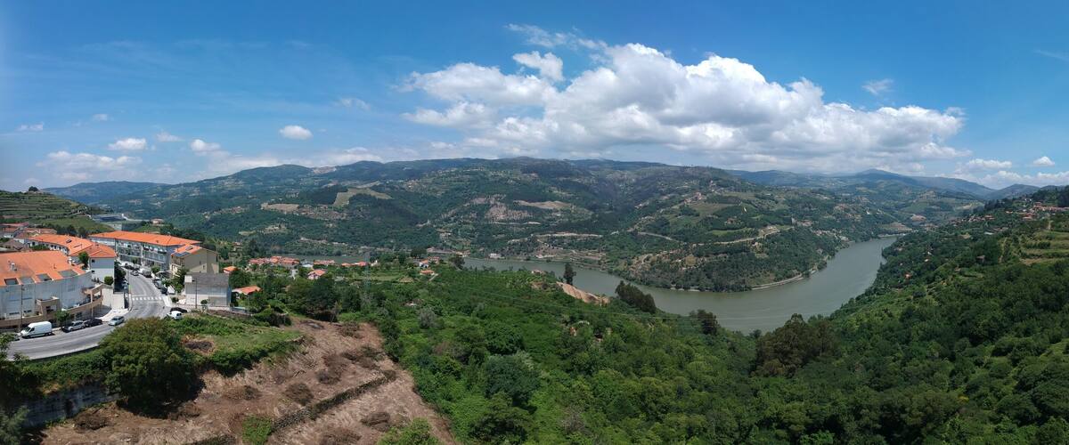 A river valley with a town on the left and a hill on the right.