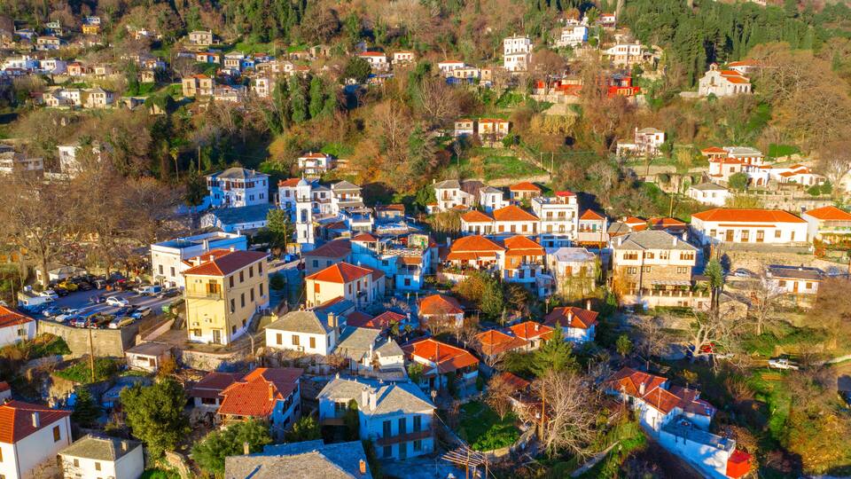 A hillside village with colorful houses and a river.