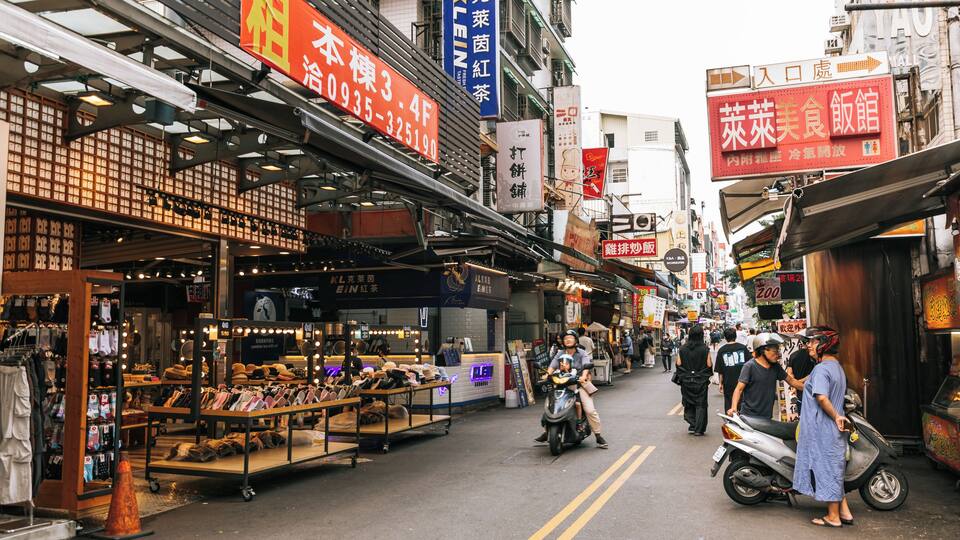 A bustling street market with various shops and stalls.