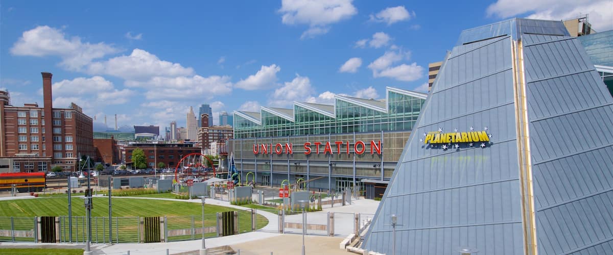Union Station with a Planetarium sign, surrounded by modern buildings and a green field.