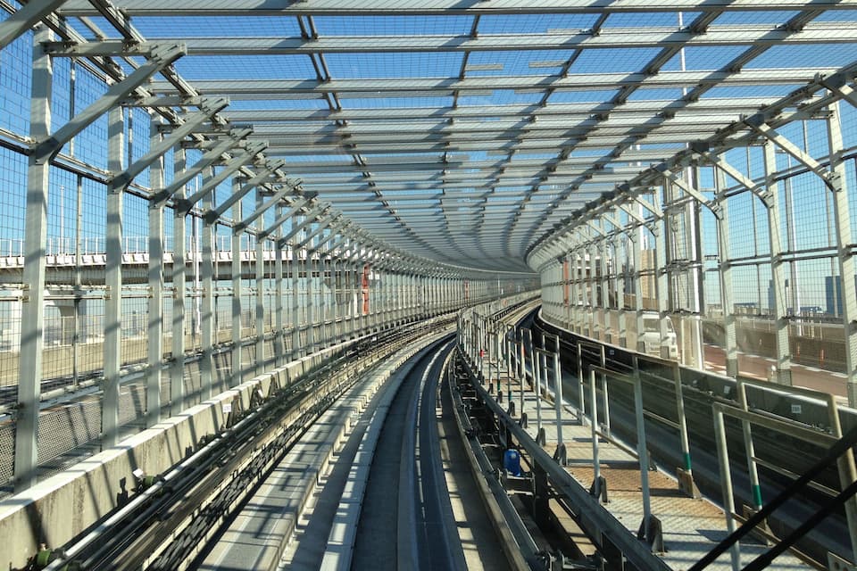 Una estación de tren moderna con techo de vidrio y varias vías.