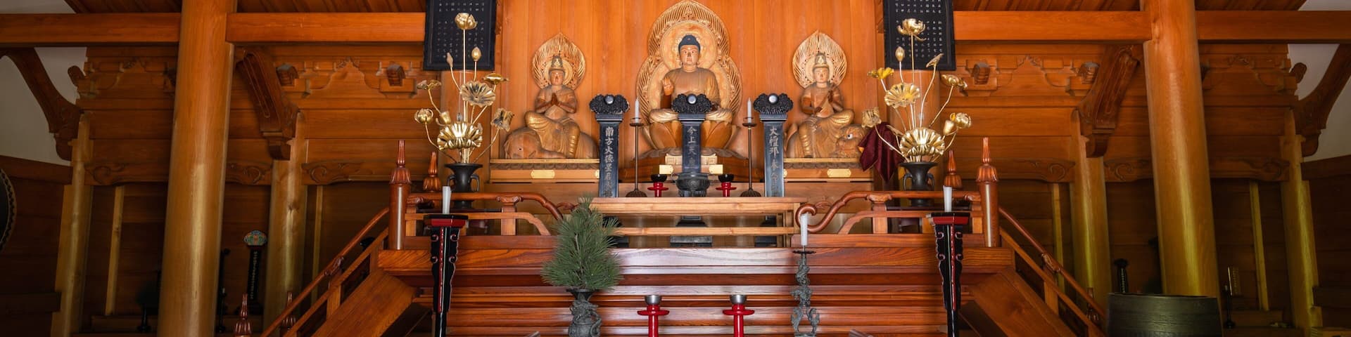 A wooden shrine with statues, incense burners, and ritual implements.