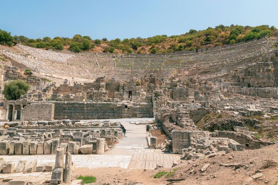 Un amphithéâtre antique doté de gradins en pierre et d’une scène centrale.