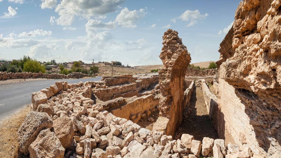 Ancient ruins with stone walls and a collapsed structure.