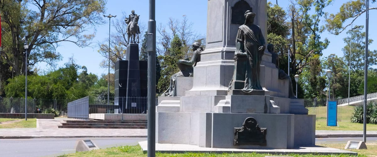 A statue of a man on a pedestal with a lamp post nearby.