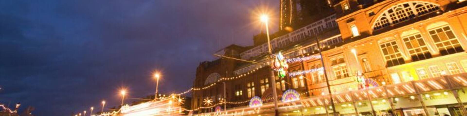 England, Lancashire, Blackpool, Golden Mile at night, low angle view (blurred motion)
